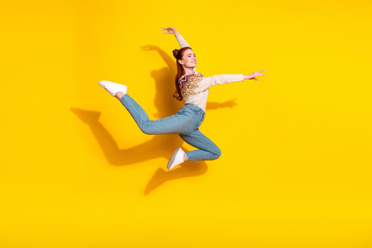 Photo portrait of attractive young woman jump dance ballerina dressed stylish knitted warm outfit isolated on yellow color background
