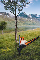 Woman relaxing in hammock enjoying mountains view in Norway girl traveling solo healthy lifestyle summer vacations in wilderness traveler with camping gear bivouac outdoor - 777218347