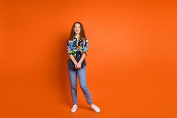 Photo of pretty adorable nice girl wear stylish print clothes hold netbook isolated on vivid orange...