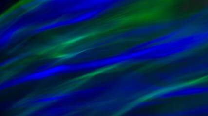 Defocused abstract green and blue background of speed camera movement over glowing lights. A...