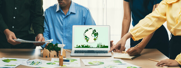 Green city logo displayed on a laptop at a green business meeting. Team presenting green design to...