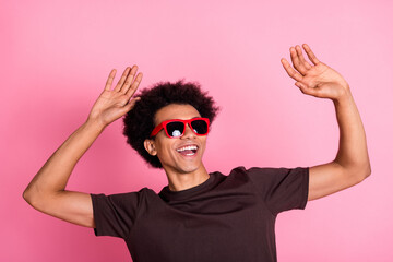 Portrait of young carefree man relax raised arms up chill out party wear sunglasses and brown t...