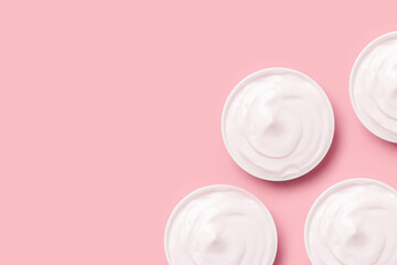 set of jars of cream in white  on a pink background.
