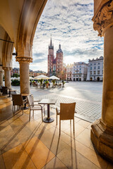 Restaurant table and chairs in the old town in Cracow, Poland. View from Cloth hall at sunrise