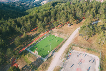 Aerial view of sport courts in the mountain forest - obrazy, fototapety, plakaty