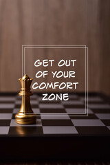 Motivational and inspirational wording. GET OUT OF YOUR COMFORT ZONE written on blurred image of queen chess piece.