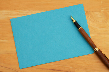 Blank blue greeting card and pen on wood - 777267796