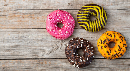Set of colorful donuts on wooden background