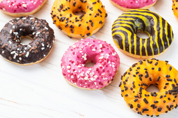 Set of colorful donuts on wooden background