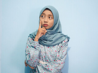 Beautiful Asian woman in blue dress and hijab is thinking about something. Isolate white background