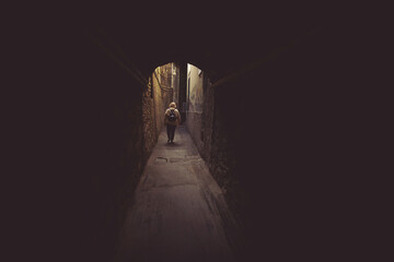 Silhouette of a woman walk in the light on the end of a dark tunnel. Woman walking the streets of Italy.