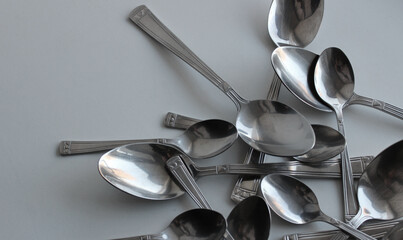 Mix Of Silvery Variety Size Spoons Closeup Angle View. Cutlery Spoons Set Concept Background
