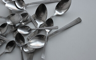 Pattern of spoons of different sizes scattered on a plastic cutting board - obrazy, fototapety, plakaty