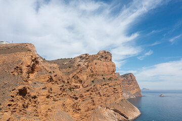Fototapeta na wymiar Aerial drone photo of the rocky cliffs located in the town of Benidorm in Spain and a sunny summer day with blue sky and white clouds.