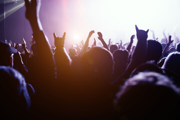 Electrifying atmosphere of a live music event, with the audience silhouetted hands. - obrazy, fototapety, plakaty