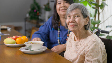 Daughter prepare lunch for elderly mother with soup.