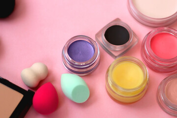 Various colorful beauty products on bright pink background. Selective focus.