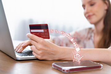 Customer holding credit card with hologram graphic interface choosing online platform. Consumer...