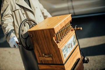 street musician playing antique vintage hand-cranked street organ music instrument