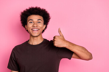 Portrait of optimistic young man wear brown t shirt thumb up symbol like respect and recommendation...