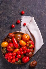 The harvest of assorted tomatoes. Colorful organic tomatoes on a large dish. Tomatoes different varieties. Top view
