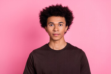 Portrait of young confident guy with chevelure hairstyle curly model in brown shirt no emotions isolated on pastel pink color background