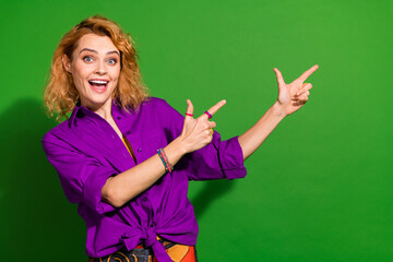 Photo portrait of attractive young girl point excited empty space dressed stylish violet garment isolated on green color background
