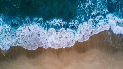 Aerial view of ocean waves meeting the sandy shore, capturing the essence of a vibrant summer beach.