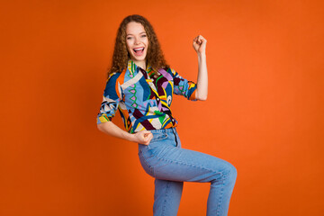 Photo of lovely charming cheerful girl wear trendy print clothes yes hooray isolated on vivid orange color background