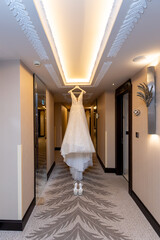 The wedding dress is hanging from the ceiling of the hotel. The bride-to-be is ready and waiting...
