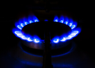 A blue flame is burning on a stove. The flame is blue and it is very bright