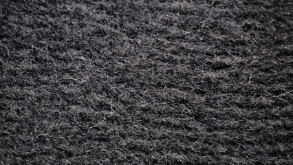 Black textile car carpet texture extreme close-up