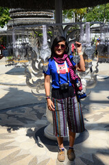 Thai travelers women people travel visit respect praying blessing wish myth mystical worship holy ancient buddha at Wat Rong Khun or Chiangrai White Temple on February 24, 2015 in Chiang Rai, Thailand