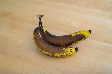 Brązowe, bardzo dojrzałe banany leżą na stole