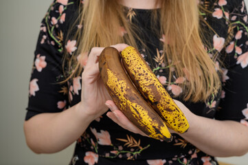 Kucharka pokazuje dojrzałe banany z brązową skórką  - obrazy, fototapety, plakaty