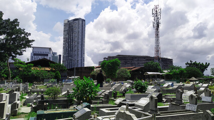 indonesia public cemetery in the middle of city center with tall building surrounding