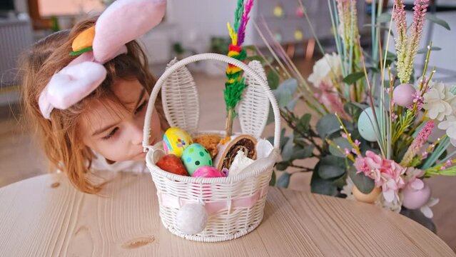 Funny Caucasian Girl Kid Dressed Up for Easter Bunny Sneaking at Traditional Polish Holy Saturday Blessed Food Basket