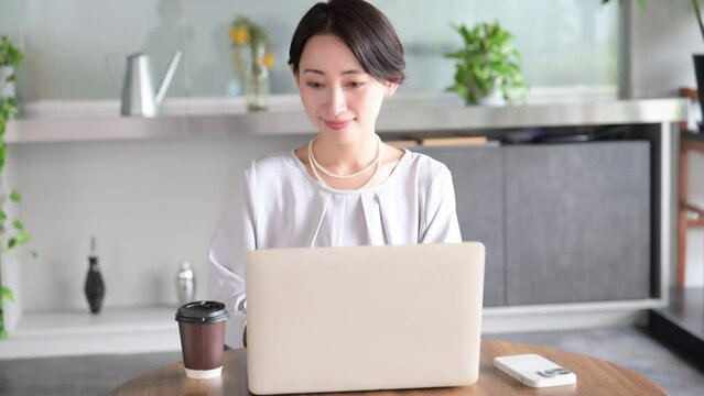 Video of a woman working with a laptop in a beautiful office or cafe.
