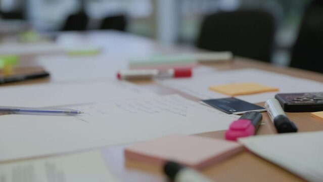Office school table covered with paper and markers for creative idea generation in slow motion