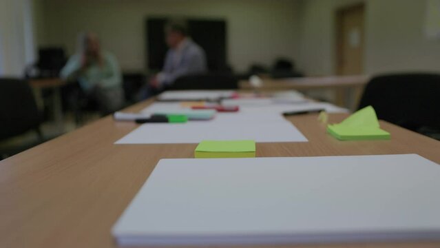 Office school table covered with paper and markers for creative idea generation in slow motion