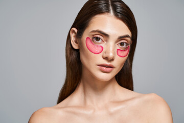 A young Caucasian woman with brunette hair showcases vibrant pink patches on her face