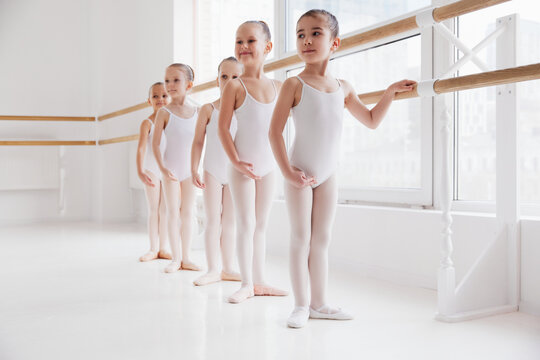 Choreographed dance by group of elegant pretty little ballerinas practicing during class at classical ballet school. Concept of art, sport, education, hobby, active lifestyle, leisure time.
