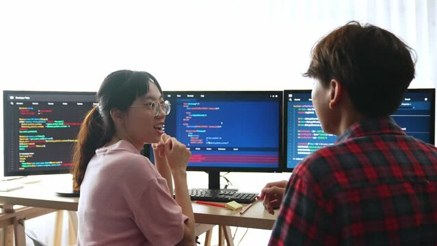 Slow motion back end software developer engineer for computer programming working together on debugging writing computing code, solving complex algorithms display on monitor in office. Burgeoning