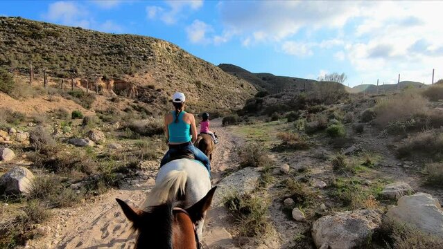Family riding horse in single file in the Cabo de Gata desert, Almeria, Andalusia, Spain. Point Of View (POV), subjective view