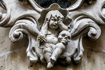 Fototapeta na wymiar Saints Michael & Gudule cathedral, Brussels, Belgium. Crying child with skull sculpture