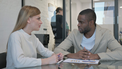 Young Man Talking During Meeting with Female Colleague