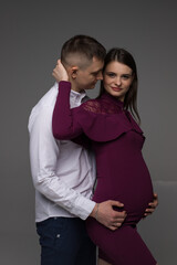 portrait of a pregnant couple on a grey background, pregnant couple close up