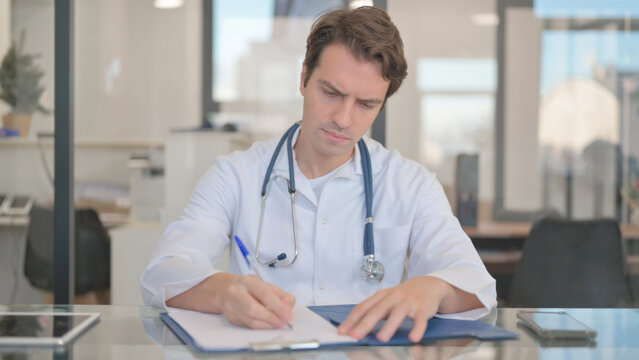 Male Doctor Working on Medical Report, Documentation