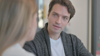 Close up of Young Man in Talk with Female Colleague