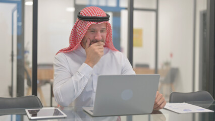 Excited Arab Man Celebrating Success on Laptop in Office